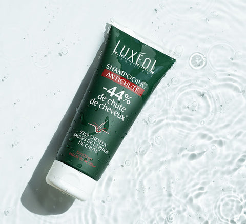 Product tube on rippling water background to suggest hydration and shine benefits.