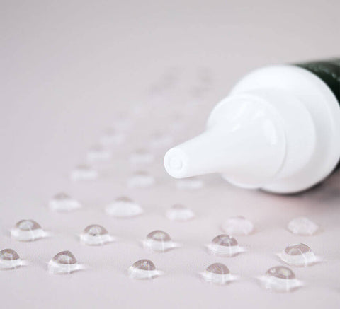 Serum droplets on clear surface.