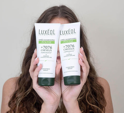 Women holding shampoo density and covering her face with products